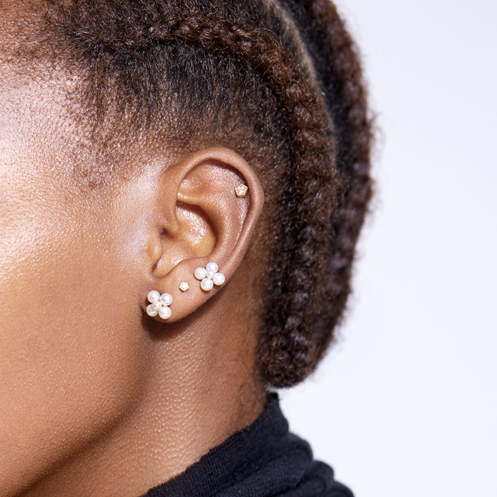 Model wearing pearl ear studs and diamond ear studs in solid gold